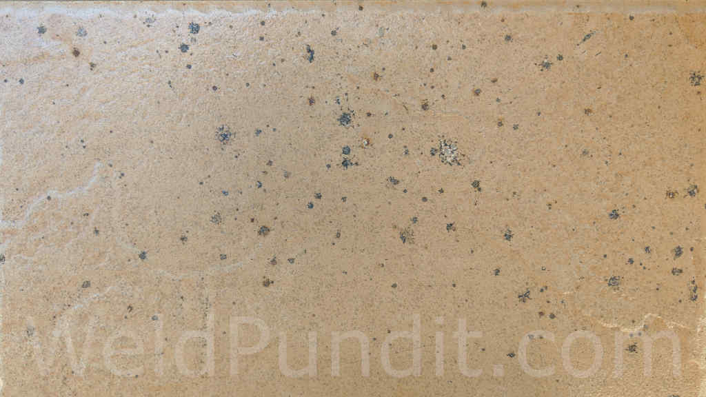 A photo of a floor tile damaged by welding spatter